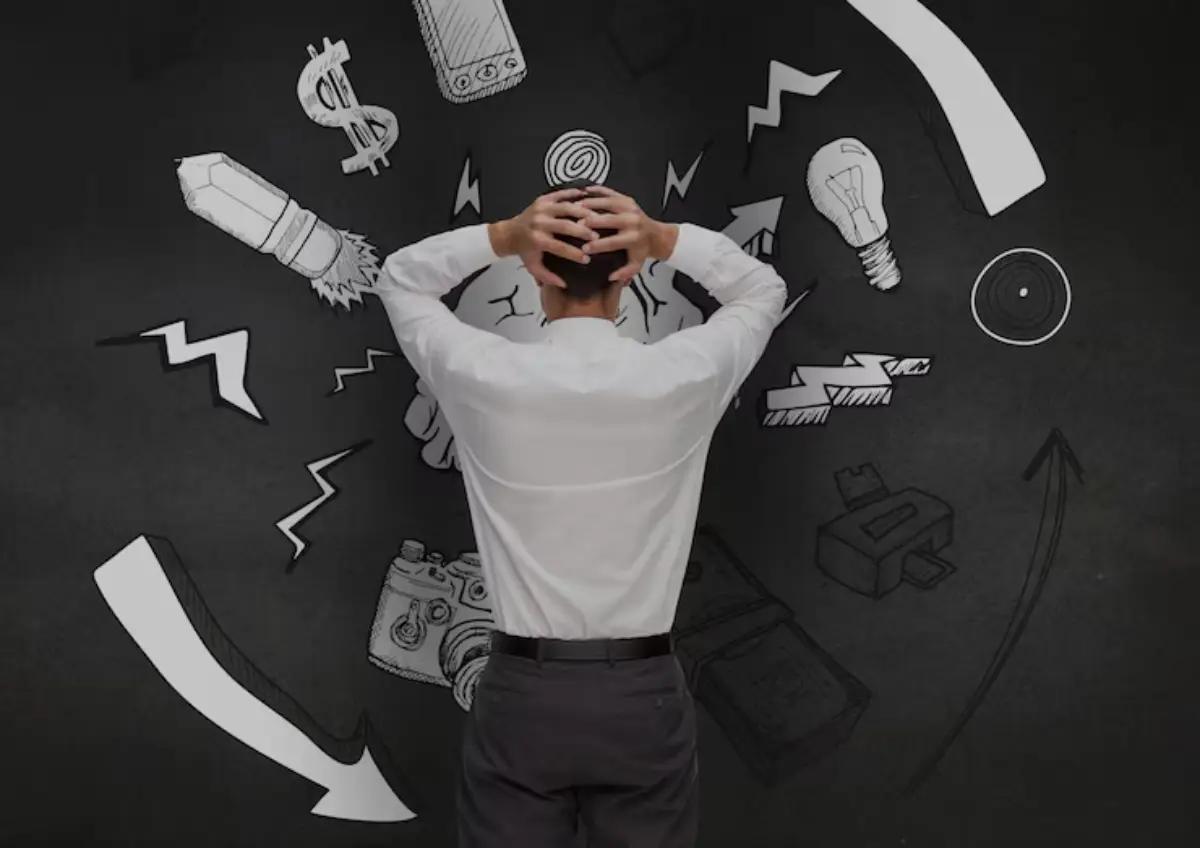 A stressed businessman, seen from behind, clutches his head as chaotic doodles symbolize confusion and pressure around him. 